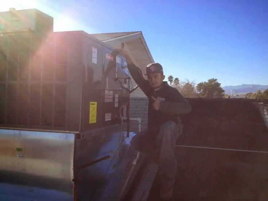 HVAC technician performing AC Tune-Up on a rooftop unit in Valle Vista